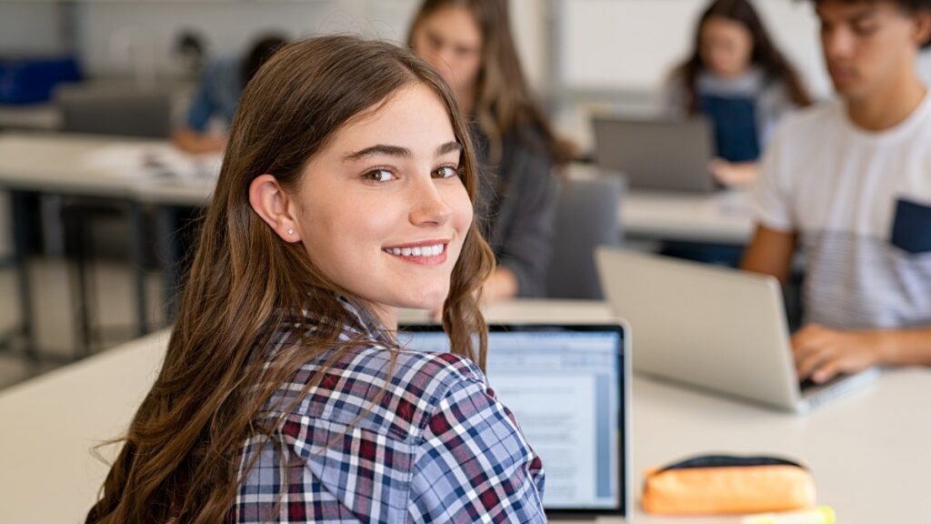 ef skill building, a girl sitting at a desk looking back able to work and initiate tasks