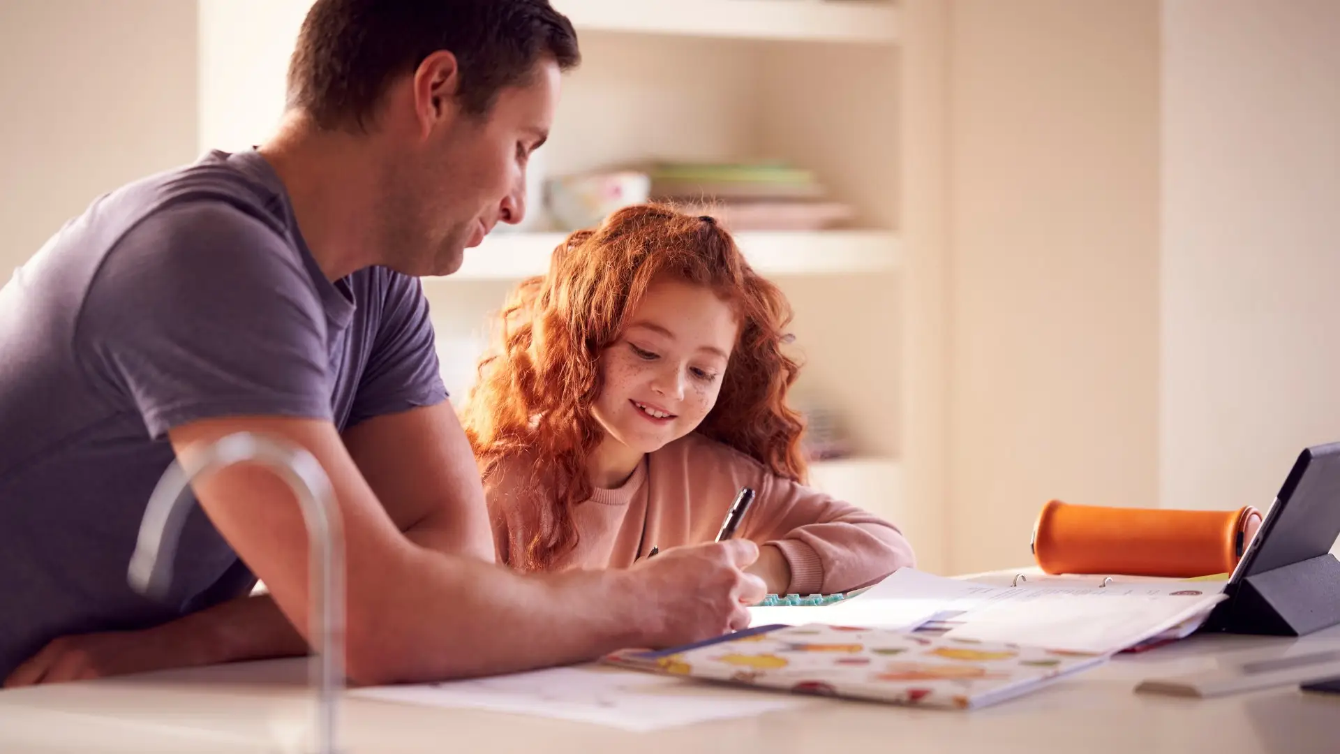 Parent and child creating an ADHD summer structure plan at the kitchen table